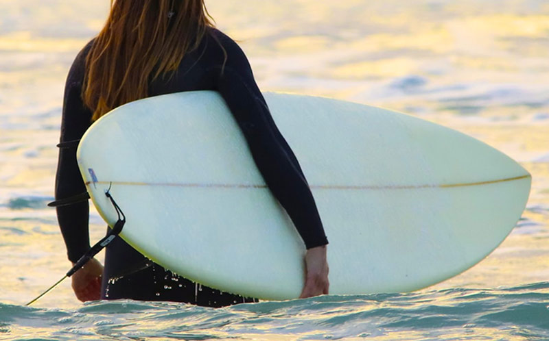 Female surfer in full wetsuit